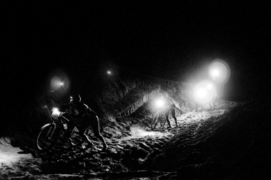 Riders push up the sandy hill in the dark or the 24 Hours of Moab endurance race.